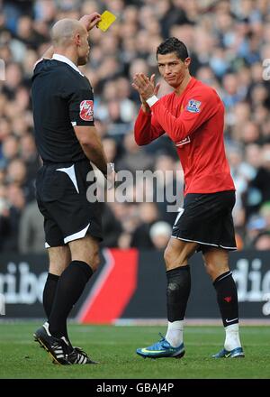 L'arbitro Howard Webb (a sinistra) mostra la carta gialla a Cristiano Ronaldo del Manchester United dopo aver foulato Shaun Wright-Phillips di Manchester City (non nella foto). Foto Stock