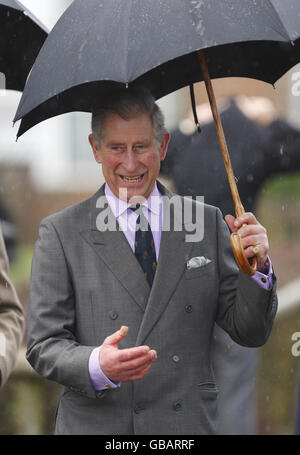 Il Principe del Galles ripara dalla pioggia sotto il suo ombrello fuori dalla Thomas Hardye School a Dorchester, Dorset. Foto Stock