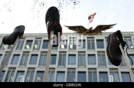 I manifestanti lanciano scarpe nell'aria fuori dall'ambasciata americana a Grosvenor Square, Londra, come parte di una manifestazione a sostegno del giornalista iracheno Muntadar al-Zaidi, detenuto per aver lanciato una scarpa al presidente americano George W Bush. Foto Stock