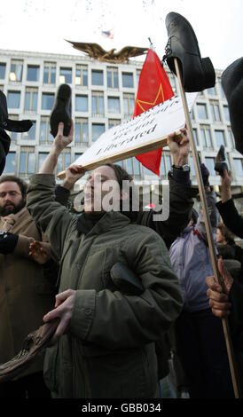 I manifestanti lanciano scarpe nell'aria fuori dall'ambasciata americana a Grosvenor Square, Londra, come parte di una manifestazione a sostegno del giornalista iracheno Muntadar al-Zaidi, detenuto per aver lanciato una scarpa al presidente americano George W Bush. Foto Stock