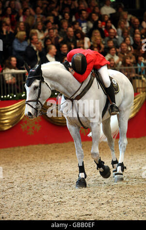 Ellen Whitaker della Gran Bretagna che cavalcano Ladina B vince congiuntamente l'Accenture Christmas Puissance durante il London International Horse Show di Olympia, Londra. Foto Stock