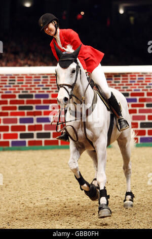 Ellen Whitaker della Gran Bretagna che cavalcano Ladina B vince congiuntamente l'Accenture Christmas Puissance durante il London International Horse Show di Olympia, Londra. Foto Stock