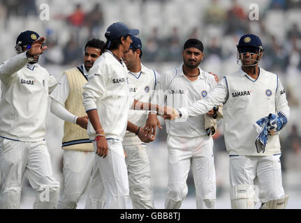 I giocatori indiani lasciano il campo dopo che Harbhajan Singh (seconda a destra) ha preso il wicket del Monty Panesar dell'Inghilterra durante il quarto giorno della seconda prova allo stadio dell'associazione del cricket di Punjab, Mohali, India. Foto Stock