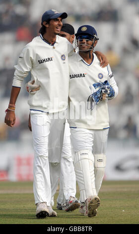 La MS Dhoni (a destra) dell'India e Ishant Sharma lasciano il campo dopo che Harbhajan Singh (non raffigurato) ha preso il wicket di Monty Panesar, terminando le incendenze dell'Inghilterra il 302 durante il quarto giorno della seconda prova al Punjab Cricket Association Stadium, Mohali, India. Foto Stock