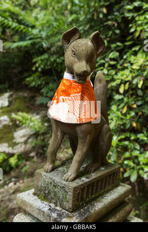 Una delle numerose statue in pietra raffigurante una volpe a Fushimi Inari santuario a Kyoto, Giappone Foto Stock