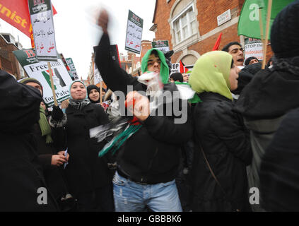 I dimostranti gettano pomodori fuori dall'ambasciata egiziana a Londra per protestare contro la campagna di bombardamento di Israele a Gaza. Foto Stock