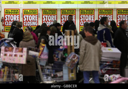 Gli acquirenti con carrelli imballati aspettano di pagare le loro merci durante l'ultimo giorno di negoziazione presso il negozio Woolworths di Edimburgo. Foto Stock