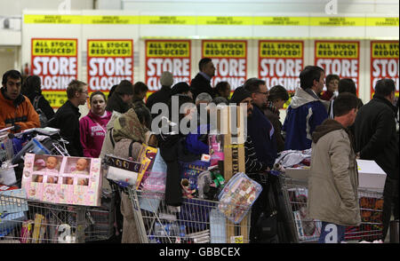 Gli acquirenti con carrelli imballati aspettano di pagare le loro merci durante l'ultimo giorno di negoziazione presso il negozio Woolworths di Edimburgo. Foto Stock