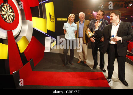 (Da sinistra a destra) Trina Gulliver, Johnny Ball, Bobby George e Ministro per l'ulteriore Educazione Sion Simon sul palco prima del World Darts Championship a Frimley Green, Surrey. Foto Stock