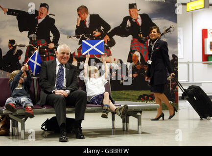 Il ministro del turismo Jim Mather (centro) con Patrick Damodaran (destra) e Paul Damodaran (sinistra) all'aeroporto di Edimburgo. I viaggiatori che arrivano nei principali aeroporti scozzesi saranno accolti con nuove immagini presentate oggi per promuovere una celebrazione annuale dei successi nazionali. Foto Stock