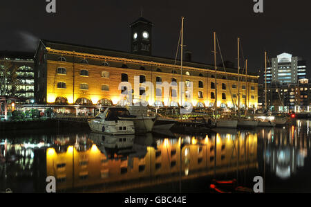 Un St Katherine's Docks illuminato che sono stati aperti nell'ottobre 1828 ad est della City di Londra, ma sono ora un porto turistico e un'attrazione turistica vicino alla Torre di Londra e al Tower Bridge. Foto Stock