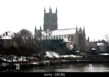 La cattedrale di Worcester si erge su una scena innevata dalle rive del fiume Severn, in città dopo la nevicata. Foto Stock