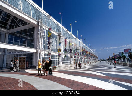 Un ampia passeggiata esterna si estende di fronte alla facciata di vetro che permette l'abbondanza di sole nella Long Beach Convention Center si trova lungo il lungomare nel centro cittadino di Long Beach, California, Stati Uniti d'America. L'imponente edificio contiene spazi espositivi e sale riunioni che sono parte di una convenzione e complesso di divertimenti che include anche due teatri e un arena per concerti ed eventi sportivi. Foto Stock