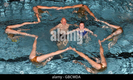 Medaglia d'oro olimpica Duncan Goodhew MBE (al centro, a sinistra) e medaglia d'oro doppia Paralimpica Eleanor Simmonds (al centro, a destra) nuotate con la squadra di nuoto sincronizzato Aquabatix per lanciare l'evento benefico Swimathon a livello nazionale presso il Centro Ricreativo Clisseley di Londra. Foto Stock