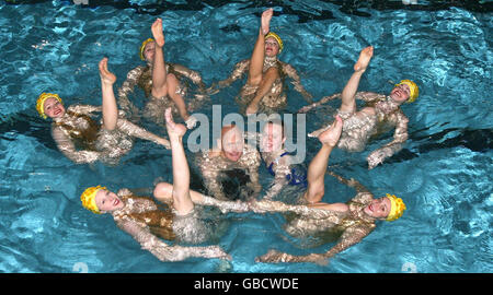 Medaglia d'oro olimpica Duncan Goodhew MBE (al centro, a sinistra) e medaglia d'oro doppia Paralimpica Eleanor Simmonds (al centro, a destra) nuotate con la squadra di nuoto sincronizzato Aquabatix per lanciare l'evento benefico Swimathon a livello nazionale presso il Centro Ricreativo Clisseley di Londra. Foto Stock