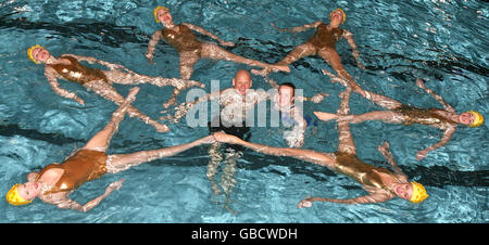 Medaglia d'oro olimpica Duncan Goodhew MBE (al centro, a sinistra) e medaglia d'oro doppia Paralimpica Eleanor Simmonds (al centro, a destra) nuotate con la squadra di nuoto sincronizzato Aquabatix per lanciare l'evento benefico Swimathon a livello nazionale presso il Centro Ricreativo Clisseley di Londra. Foto Stock