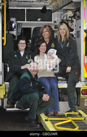 Cordelia Nolan, 25 anni, con il suo bambino Emrys di 12 settimane e il personale paramedico e di supporto che ha aiutato la signora Nolan a salvare la vita del suo bambino quattro volte in 10 minuti. Foto Stock