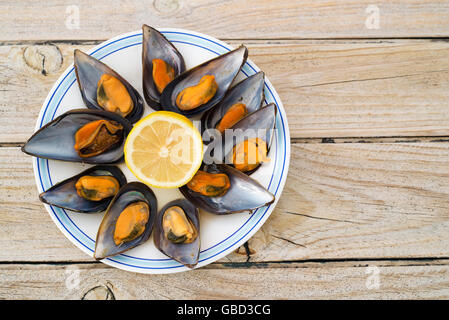 Le cozze al vapore su un tavolo di legno. spazio copia Foto Stock