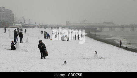 Le persone si riuniscono sulla spiaggia di Brighton dopo la notte sulla neve. Foto Stock