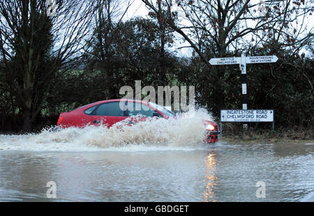 Un'auto attraversa le acque alluvionali nel villaggio di Blackmore, Essex. Foto Stock