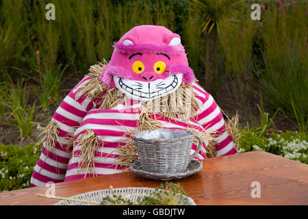 Grinning Cheshire Cat in rosa al Mad Hatter's Tea Party, Alice in Wonderland Effigy o Scarecrow si sono riuniti per il Fleetwood Festival   Tea party con il Mad Hatter, Alice's Adventures in Wonderland, Lancashire, UK Foto Stock
