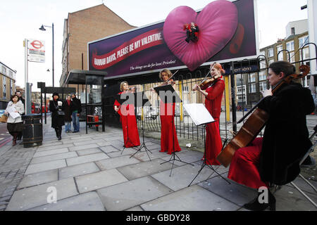 Un Quartetto d'archi ha creato l'atmosfera di Johnny Skinner di Shoreditch, che si è fatto parte di un cartellone Mastercard su Old Street, Londra, per dichiarare il suo amore per Hannah Davis. Foto Stock