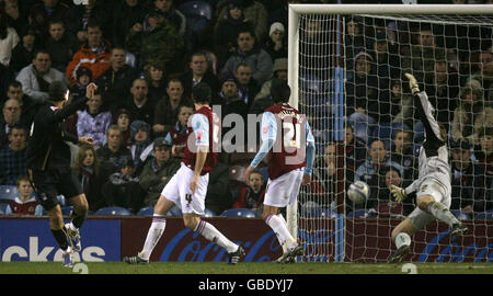 Il miglior leone di Coventry City (a sinistra) segna il portiere Burnley Brian Jensen durante la partita del campionato Coca-Cola a Turf Moor, Burnley. Foto Stock