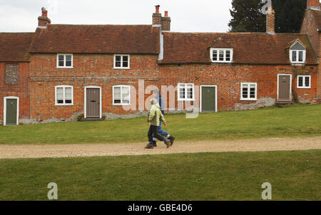 I visitatori passeranno davanti ai cottage degli ex costruttori di navi a Buckler's Hard vicino a Beaulieu, nell'Hampshire. Foto Stock