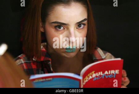 Un modello legge un backstage del libro prima dell'Ashish Catwalk Show, all'Ippodromo, Leicester Square, come parte della settimana della moda di Londra. Foto Stock