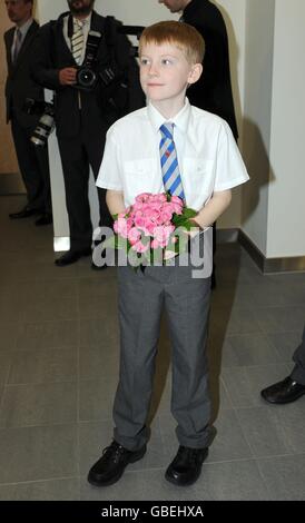 George Taylor di 9 anni prima di presentare alla regina Elisabetta II un bouquet prima di aprire ufficialmente la nuova sede della Legione britannica a Londra del sud. Foto Stock