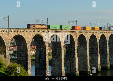 Trasporto merci treno che viaggia oltre il viadotto ferroviario costruito da Robert Stevenson a Berwick-upon-Tweed, England, Regno Unito Foto Stock