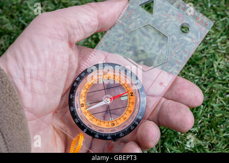 Concetto di navigazione, direzione e sapere dove si sta andando o trovare il vostro modo, illustrata da un hand-held bussola magnetica. Direzione nord. Foto Stock