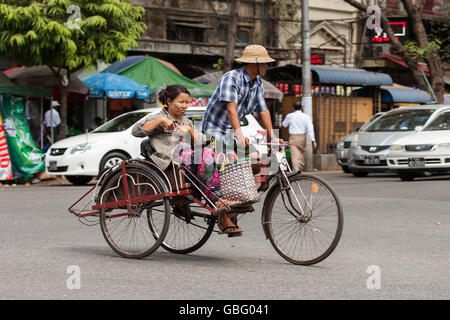 YANGON, MYANMAR - Gennaio 2, 2016: Unidentified uomo a cavallo di un riscio' per le strade di Yangon , il Myanmar il 2 gennaio 2016. Foto Stock