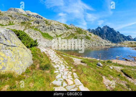 Hiking path along beautiful lake in Starolesna valley in summer time, High Tatra Mountains, Slovakia Foto Stock