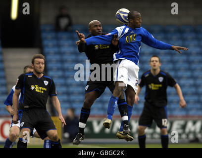 Barry Hayles di Leicester City (al centro a sinistra) e Jimmy Abdou di Millwall saltano per una testa durante la partita della Coca-Cola League One al New Den, Londra. Foto Stock