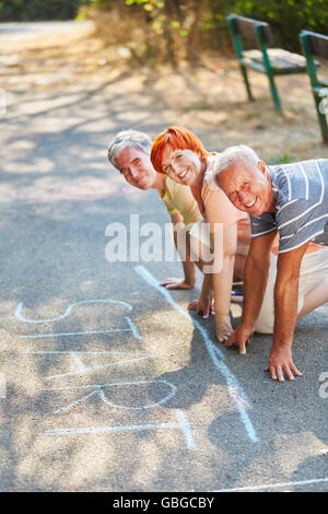 Team contento di anziani pronto per iniziare la corsa nel parco in estate Foto Stock