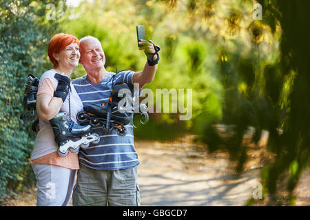 Felice coppia senior prendendo un selfie con loro saktes inline nella natura Foto Stock