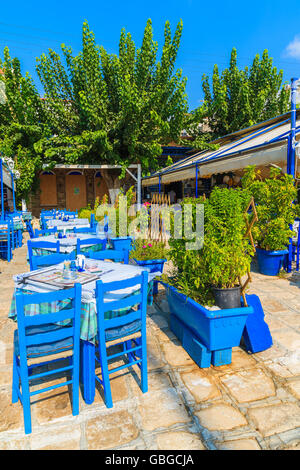 PYTHAGORION PORTA, isola di Samos - Sep 19, 2015: sedie blu con tavoli in tipico ristorante greco nel porto di Pythagorion su Sam Foto Stock