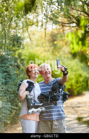 Coppia senior con pattini in natura prendendo un selfie Foto Stock