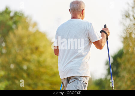 Senior uomo facendo una passeggiata nordica per la riabilitazione nella natura Foto Stock