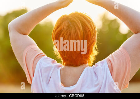 Senior donna fare esercizi di yoga e di meditazione nel parco Foto Stock