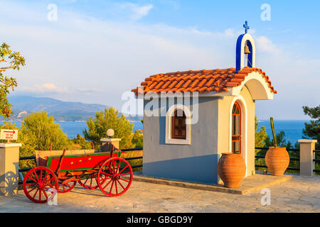 Piccola cappella Greca sulla costa di Isola di Samos nella calda luce del tramonto, Grecia Foto Stock