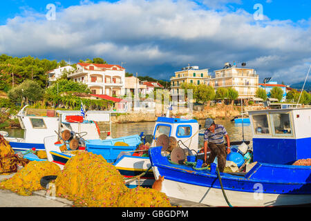 Unidentified pescatore del lavoro greco sulla barca da pesca all'alba nel piccolo porto, Samos Island, Grecia Foto Stock