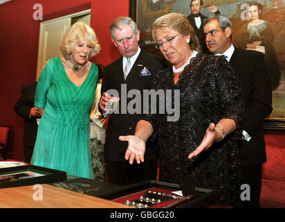 Il Principe di Galles e la Duchessa di Cornovaglia sono presentati con doni dal Presidente cileno Michelle Bachelet (a destra) prima di una cena di Stato nella sua casa ufficiale la Moneda palazzo a Santiago. Foto Stock