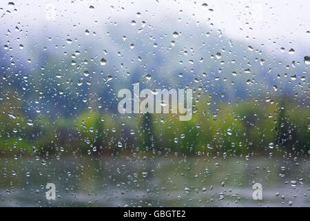 Vista sul fiume attraverso la finestra nella giornata di pioggia. Giorno di pioggia. Gocce di pioggia. Gocce di pioggia sfondo. Foto Stock