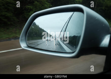 In autostrada in vista di pioggia da specchietto laterale Foto Stock