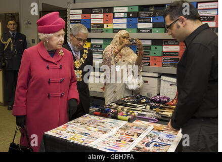 La Regina Elisabetta II della Gran Bretagna e il Sindaco e la Mayoressa di Tower Hamlets a Londra, Cllr Abdus Mohammed Salique e Razia Begum Salique, guardano ad una selezione di disegni tessili durante una visita agli ombrelli Fulton sull'Isola dei cani a Londra. Foto Stock