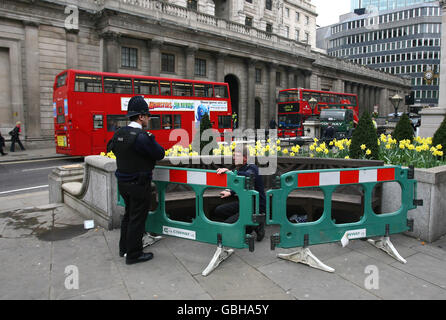 Gli agenti di polizia scoprono un dispositivo sospetto sotto una panchina fuori dalla stazione della Banca d'Inghilterra e della Banca della città di Londra, prima delle attese proteste del G20 di domani. Foto Stock