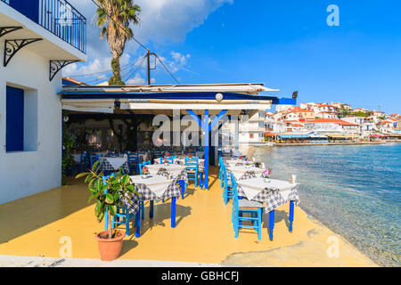 KOKKARI, isola di Samos - Sep 25, 2015: tavoli con sedie in una tradizionale taverna greca in Kokkari cittadina sulla costa di Isola di Samos, G Foto Stock