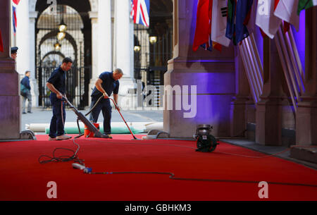 Il personale prepara il tappeto rosso prima che gli ospiti arrivino al 10 di Downing Street per partecipare a una cena prima del vertice del G20. Foto Stock